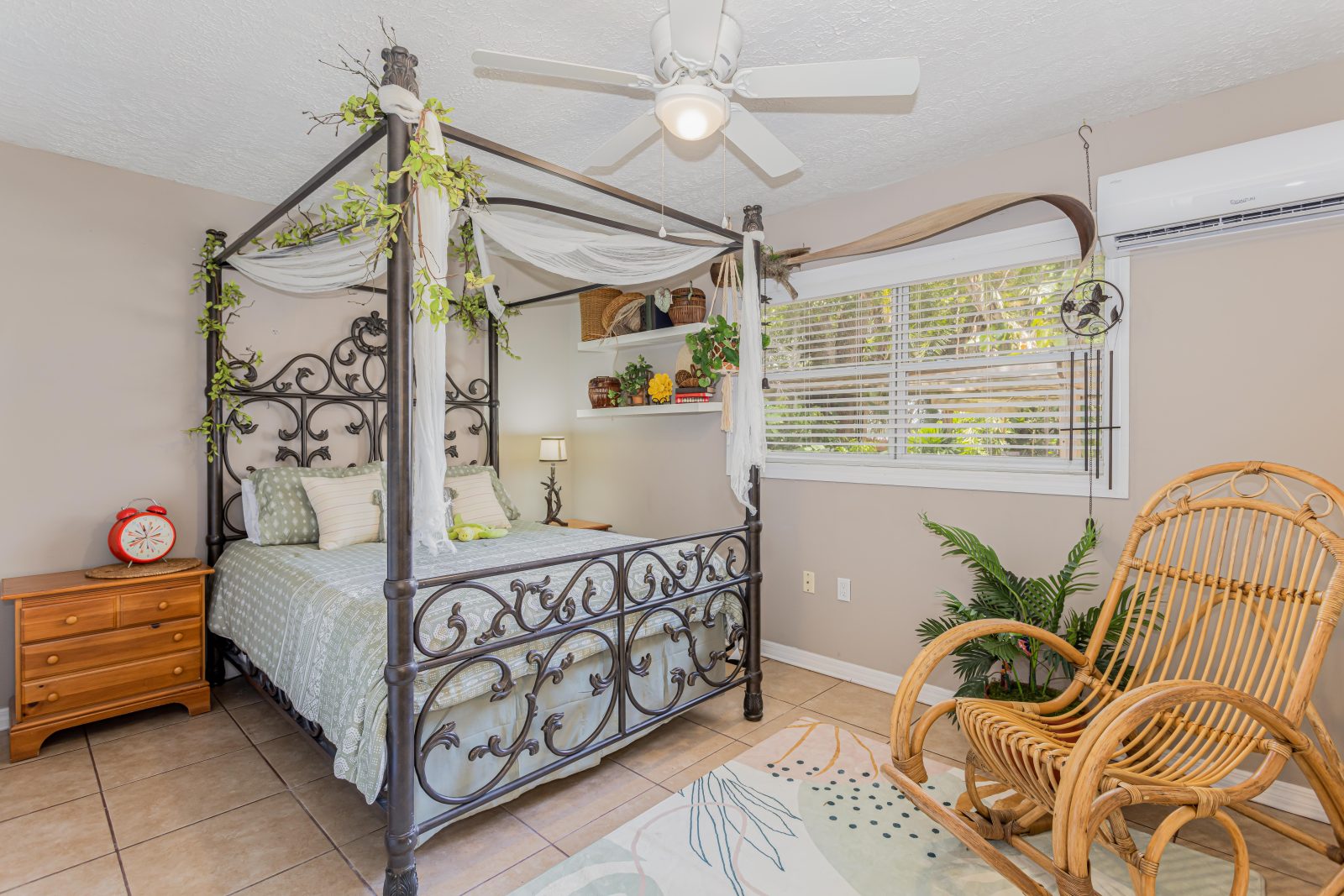 Tropical bedroom with iron canopy bed and rattan rocking chair