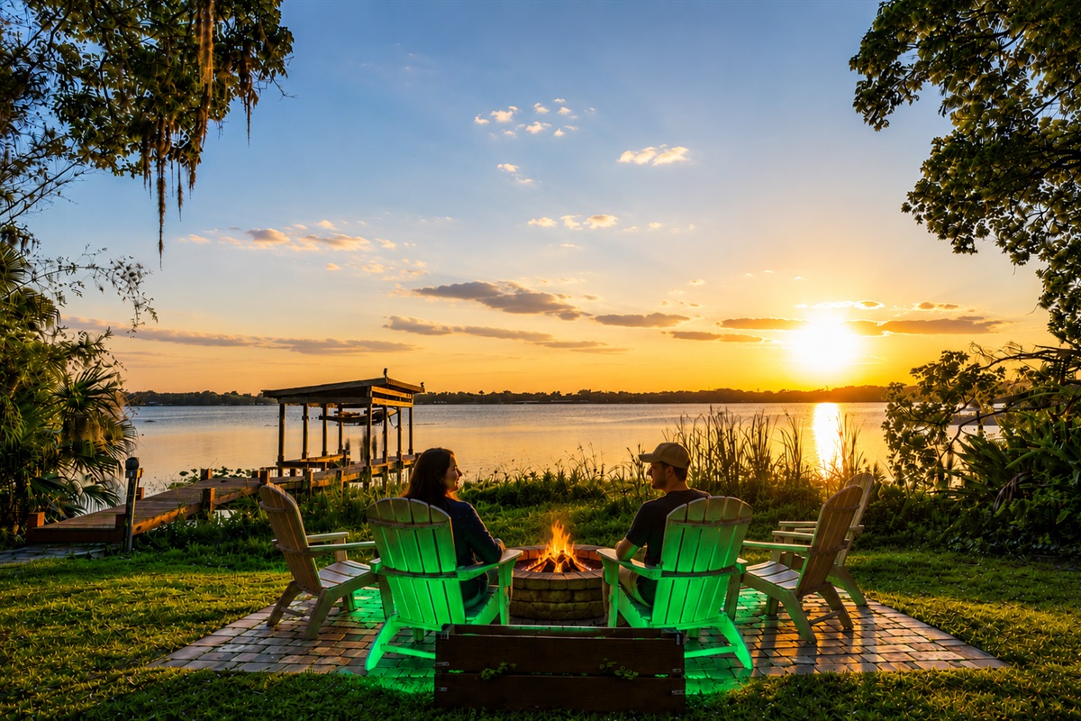 Lakefront fire pit and Adirondack chairs at sunset by the dock