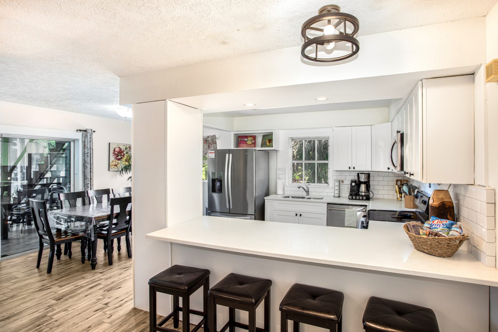 Kitchen breakfast bar with stools and dining area beyond