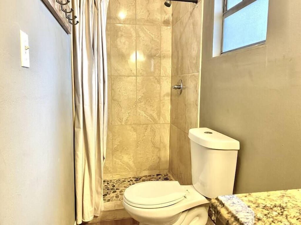 Bathroom with tiled walk-in shower and pebble floor
