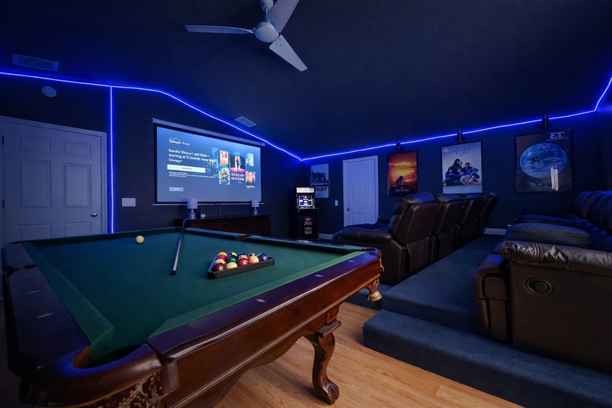 Game room with pool table, projector screen, theater recliners and arcade