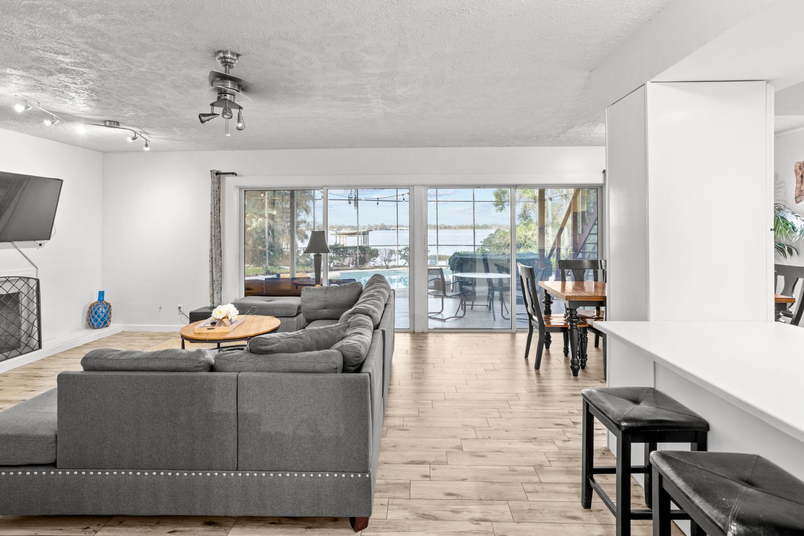 Living and dining area with sectional and lake views through sliders