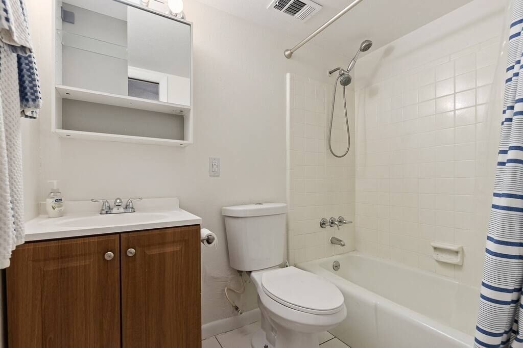 Bathroom with single vanity and shower-tub combo