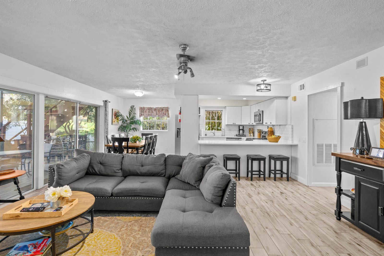 Open living room with sectional sofa beside kitchen and dining area