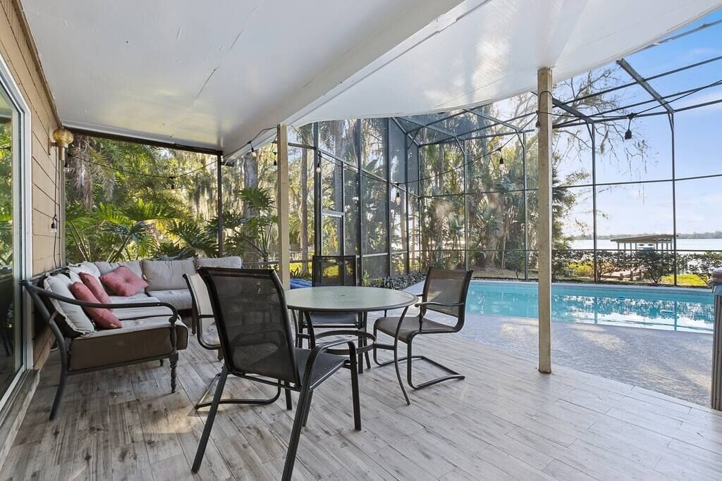 Covered lanai seating overlooking the screened pool and lake