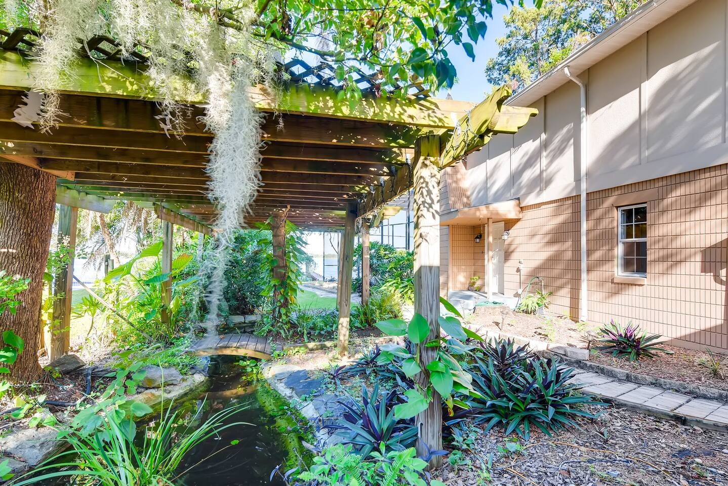Pause beneath a mossy pergola in the lush garden courtyard.
