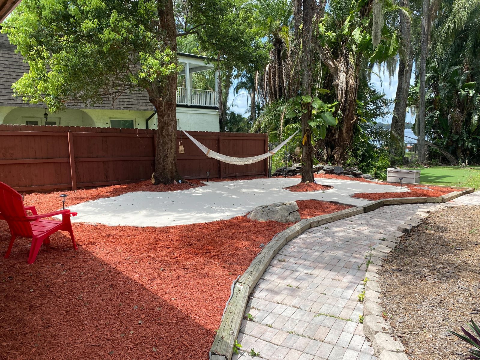 Swing in the hammock on a shaded sandy garden patio.